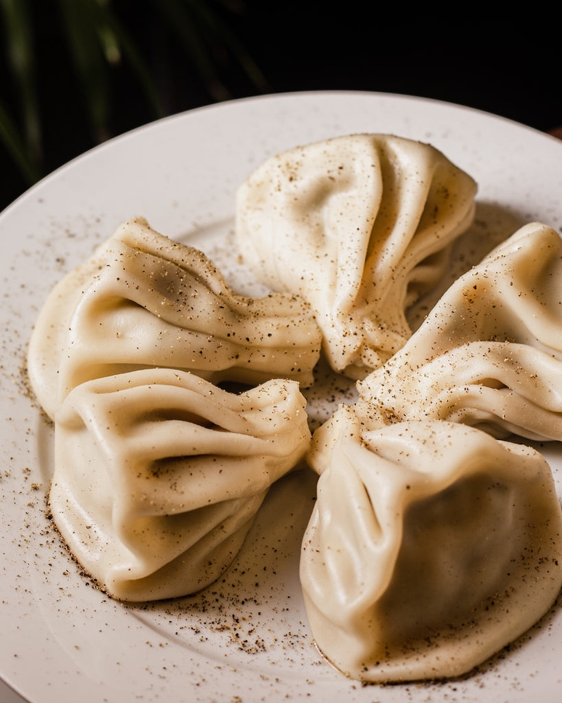 5 dumplings arranged in a circle on a small plate